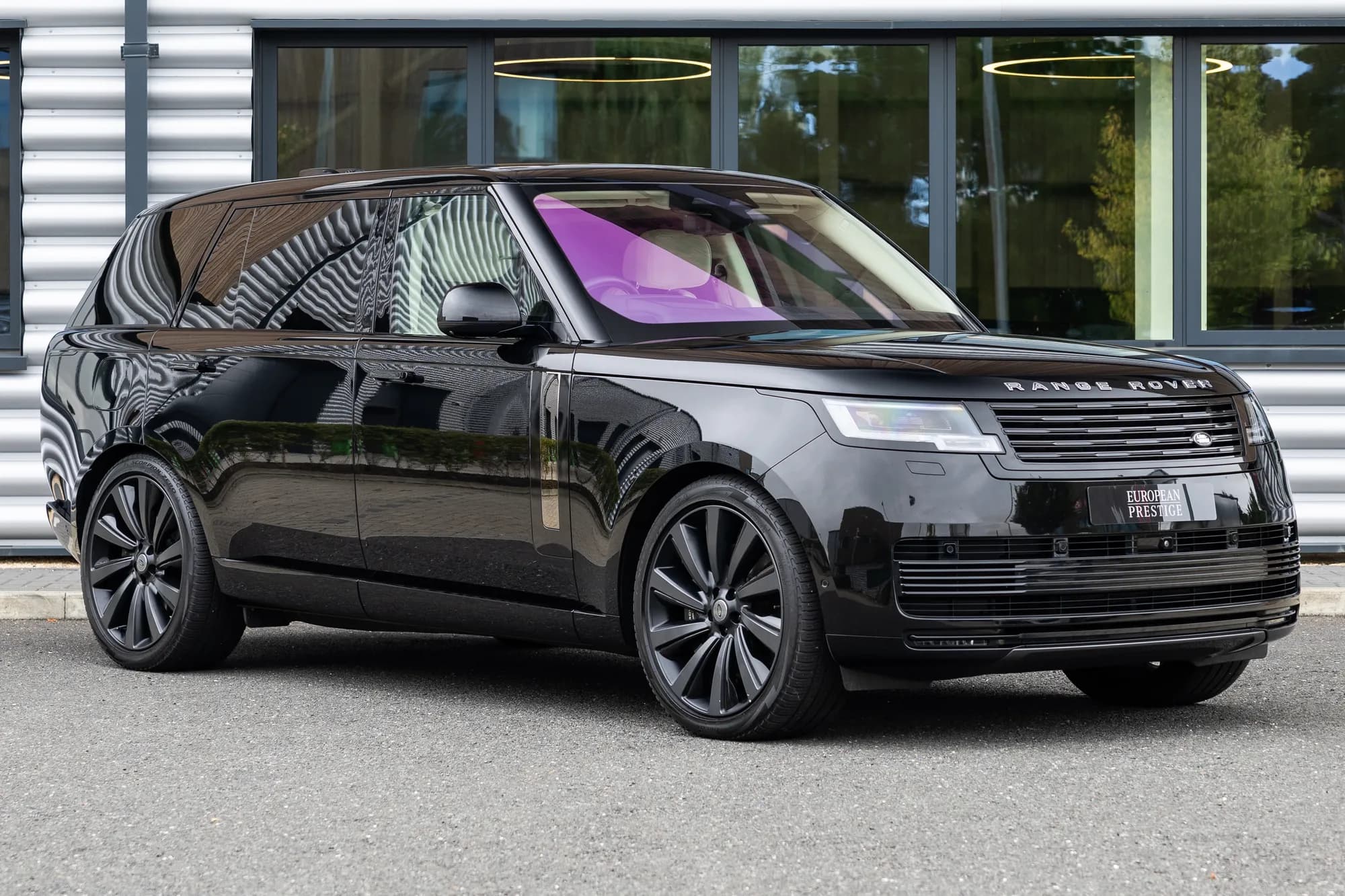 Vorderansicht des Range Rover Autobiography von schräg vorne vor einem modernen Gebäude
