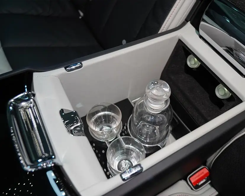 Detailansicht der hinteren Armlehne des Rolls-Royce Phantom mit Kristallgläsern und Karaffe